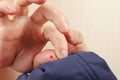 Hands of clothier pinned the pin to blue synthetic clothes closeup