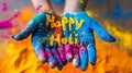 Hands holding a handful of colored powder paints with the text Happy Holi