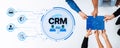 Hands Collaborating on CRM Concepts with Digital Icons Representing Customer Relationship Management Solutions Trope Royalty Free Stock Photo