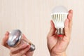 Hands compared incandescent bulb and ecofriendly led lamp Royalty Free Stock Photo