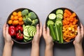 hands comparing veggies before and after skewering