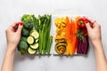 hands comparing veggies before and after skewering