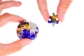 Hands Completing Earth Puzzle with Globe Background