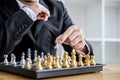 Hands of confident businessman playing chess game to development analysis new strategy plan, leader and teamwork concept for win Royalty Free Stock Photo