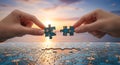 Hands connect final network puzzle pieces at sunset Royalty Free Stock Photo