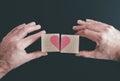 Hands connecting or disconnecting woodenblocks with red heart