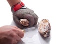 Hands of the cook opening an oyster