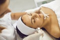 Hands of cosmetologist making facial regeneration treatment for woman in spa salon Royalty Free Stock Photo