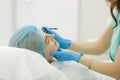 Hands of cosmetologist making preparation for face contouring plasty. Young woman gets beauty facial injections in salon Royalty Free Stock Photo