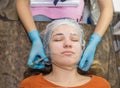 The hands of a cosmetologist put a film on the face of a woman. anesthesia before the procedure of mesotherapy, biorevitalization