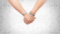 Hands of couple with gay pride rainbow wristbands