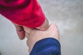the hands of a couple holding hands against the background of beach sand. Royalty Free Stock Photo
