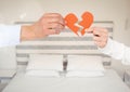 Hands of couple holding a broken heart in bedroom Royalty Free Stock Photo