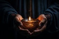 Hands cradling a candle, with its soft, warm glow as the sole source of light, symbolizing the power of a single flame to dispel