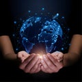 Hands cradling glowing Earth on dark, symbolizing global tech connectivity Royalty Free Stock Photo