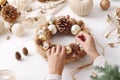 Hands crafting festive Christmas holiday wreath with ornaments. Royalty Free Stock Photo