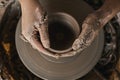 Hands of craftsman artist working on pottery wheel