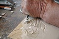 Hands of the craftsman carve a bas-relief in wood Royalty Free Stock Photo