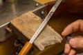 Hands of a craftsman jeweler working on jewelry. Goldsmith. Jewelery and valuable articles workshop. Engraving on a sword: Espada