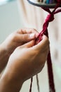 Hands of a craftsman knitting handmade macrame.