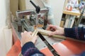 Hands of a craftsman using a professional underpinning machine to join a wooden picture frame. Royalty Free Stock Photo