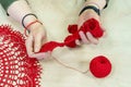 Hands of a craftswoman with a ball of red threads. Unusual hobby crochet. Background with copy space Royalty Free Stock Photo