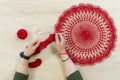 Hands of a craftswoman with a ball of red threads. Unusual hobby crochet. Background with copy space Royalty Free Stock Photo