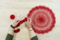 Hands of a craftswoman with a ball of red threads. Unusual hobby crochet. Background with copy space Royalty Free Stock Photo