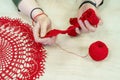 Hands of a craftswoman with a ball of red threads. Unusual hobby crochet. Background with copy space Royalty Free Stock Photo