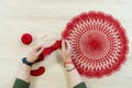 Hands of a craftswoman with a ball of red threads. Unusual hobby crochet. Background with copy space Royalty Free Stock Photo