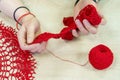 Hands of a craftswoman with a ball of red threads. Unusual hobby crochet. Background with copy space Royalty Free Stock Photo