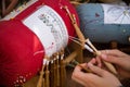 Hands of craftswoman making bobbin lace
