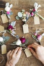 Hands creating boutonnieres with paper tags Royalty Free Stock Photo