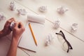 Hands crumpling paper on wooden desk