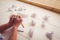 Hands crumpling paper on wooden desk