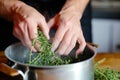 hands crushing fresh thyme over a pot for a homemade steam remedy