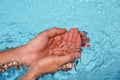 The hands cupped together submerged in clean clear blue water in swimming pool Royalty Free Stock Photo