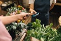 Hands of a customer and a vendor making transaction with a credit card and a pos terminal. Unrecognizable woman paying via plastic Royalty Free Stock Photo