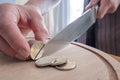 Hands cut euro coins with a knife, separating them like pieces of food, on a cutting board. Concept of taxes, fraud or