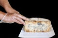 hands cut a large piece of stilton cheese. Isolated on a black background Royalty Free Stock Photo