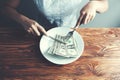 Hands cut money on plate reduce funds concept Royalty Free Stock Photo