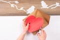 Hands cut out with scissors a paper heart. Royalty Free Stock Photo