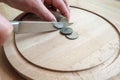 Hands cut dollar coins with a knife, separating them like pieces of food on a cutting board. Concept of taxes, fraud or