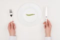 Hands, cutlery and pea on plate Royalty Free Stock Photo