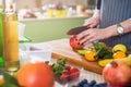 Hands cutting an apple on chopping board. Young woman preparing a fruit salad in her kitchen Royalty Free Stock Photo