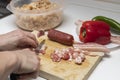 Hands cutting bacon. Extremadura crumbs, traditional home cooking with bacon, chorizo, garlic, breadcrumbs, red and green peppers