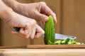 Hands cutting cucumber on the wooden cutting board Royalty Free Stock Photo