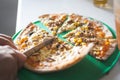 Cutting pizza into slices with knife. Royalty Free Stock Photo