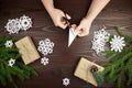 Hands cutting white paper snowflakes over wooden table Royalty Free Stock Photo