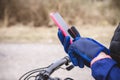 Hands of a cyclist in gloves hold a smartphone. Traveler looking for directions using maps in smartphone Royalty Free Stock Photo